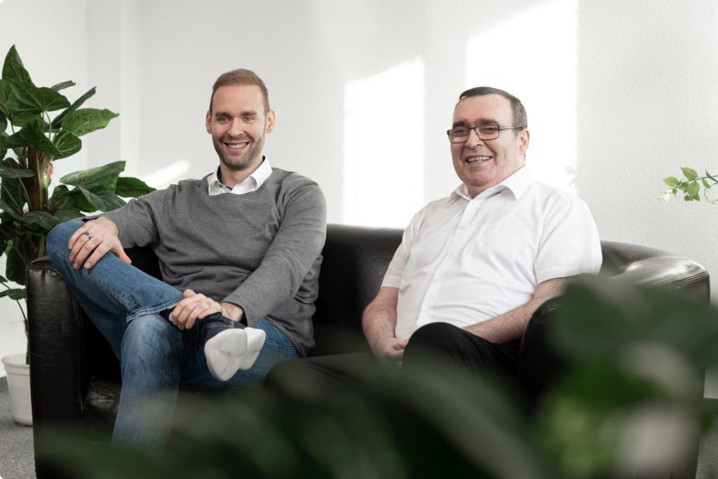 Firmeninhaber der CSAE GmbH sitzen auf einer Couch